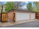 Three-car garage with white doors and a brick exterior, complemented by a wooden privacy fence on the side at 963 N Lafayette St, Denver, CO 80218