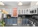 Updated kitchen with stainless steel appliances, granite counters, and white and blue cabinets at 963 N Lafayette St, Denver, CO 80218