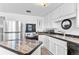 Bright kitchen with white cabinets, stainless steel refrigerator and black appliances at 816 Forest St, Denver, CO 80220