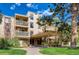 Exterior of a multi-story condo with a covered entryway, balconies, and lush landscaping at 1304 S Parker Rd # 359, Denver, CO 80231