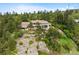 Aerial view of a home on a rocky outcropping with lush landscaping and a tile roof at 857 Pawnee Trl, Castle Rock, CO 80108