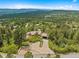 Aerial view of an estate with a tile roof surrounded by lush landscaping and a paved driveway at 857 Pawnee Trl, Castle Rock, CO 80108