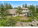 Landscaped backyard featuring lush greenery, steps to the home, and rocky hillside at 857 Pawnee Trl, Castle Rock, CO 80108