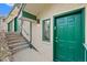 Charming front entrance with a green door, steps and a well-lit porch at 857 Pawnee Trl, Castle Rock, CO 80108