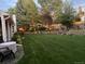 Landscaped backyard featuring a verdant lawn, ambient lighting, and inviting outdoor seating at 7946 S Pennsylvania Ct, Littleton, CO 80122