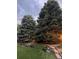 Lush backyard showcasing mature evergreens, a tiered garden, and a cozy bench at 7946 S Pennsylvania Ct, Littleton, CO 80122