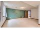 Finished basement area featuring a green accent wall, neutral carpet, and a walk-in closet at 7946 S Pennsylvania Ct, Littleton, CO 80122