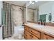Well-lit bathroom featuring a shower-tub combination, a single sink with a wooden vanity, and neutral tile at 7946 S Pennsylvania Ct, Littleton, CO 80122