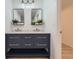 Stylish bathroom with double sink vanity, modern lighting, and updated mirrors at 7946 S Pennsylvania Ct, Littleton, CO 80122