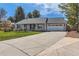 Charming single-story home featuring a well-manicured lawn and a spacious two-car garage with a large driveway at 7946 S Pennsylvania Ct, Littleton, CO 80122