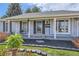 Inviting front porch with stone accents, decorative shutters, updated windows, and a charming flag at 7946 S Pennsylvania Ct, Littleton, CO 80122