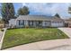 Well-maintained, single-story home with lush green lawn, stone accents, and mature trees, with ADT security sign at 7946 S Pennsylvania Ct, Littleton, CO 80122