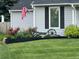 A charming front yard featuring a black decorative garden bed, lush lawn, and American flag at 7946 S Pennsylvania Ct, Littleton, CO 80122