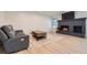 Comfortable living room boasts a painted brick fireplace, light wood floors, and modern finishes at 7946 S Pennsylvania Ct, Littleton, CO 80122