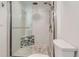 Beautiful shower featuring a glass door, rainfall shower head, and mosaic tile accent at 7946 S Pennsylvania Ct, Littleton, CO 80122