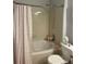 Clean bathroom with a shower/tub combination, floral shower curtain, and neutral-toned tile at 10457 W Hampden Ave # 104, Lakewood, CO 80227