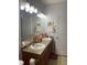 Bright bathroom featuring a large mirror, double sink vanity, and two doors at 10457 W Hampden Ave # 104, Lakewood, CO 80227