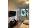 Bright bedroom with a tv, window seat, and decorative plants, creating a relaxing space at 10457 W Hampden Ave # 104, Lakewood, CO 80227
