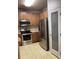 Well-equipped kitchen featuring stainless steel appliances, wood cabinetry, and a convenient pantry door at 10457 W Hampden Ave # 104, Lakewood, CO 80227