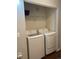 A washer and dryer inside of a laundry closet with wire shelving for storage at 10457 W Hampden Ave # 104, Lakewood, CO 80227