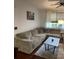 Spacious living room with large comfortable couch, coffee table, and picture window at 10457 W Hampden Ave # 104, Lakewood, CO 80227