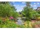 Scenic view of pond with green trees and pink flowers at 10457 W Hampden Ave # 104, Lakewood, CO 80227