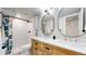 Modern bathroom featuring a double vanity, stylish mirrors, and a walk-in shower at 3064 S Holly Pl, Denver, CO 80222