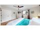 Bright bedroom featuring light walls, wooden floors, white closet doors, a ceiling fan, and a large window at 3064 S Holly Pl, Denver, CO 80222