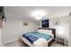 Cozy bedroom featuring carpet, light walls, a ceiling light fixture and a mounted TV at 3064 S Holly Pl, Denver, CO 80222