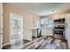Bright kitchen featuring stainless steel appliances, white cabinets, and stylish gray wood-look flooring at 1746 Galena St, Aurora, CO 80010