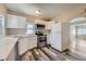 Bright kitchen features stainless steel appliances, white cabinetry, and gray wood-look flooring at 1746 Galena St, Aurora, CO 80010