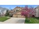 Charming home with a well-kept lawn, mature tree, and a spacious driveway leading to a two-car garage at 14820 E Maplewood Dr, Centennial, CO 80016
