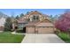 Inviting two-story home with a manicured lawn, dual-car garage, and blossoming trees at 14820 E Maplewood Dr, Centennial, CO 80016