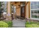 Inviting front porch featuring stone accents, a secure front door, and lush landscaping at 14820 E Maplewood Dr, Centennial, CO 80016
