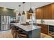 Renovated kitchen with stainless steel appliances, stone countertops, a kitchen island and custom cabinets at 14820 E Maplewood Dr, Centennial, CO 80016
