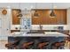 Updated kitchen features an island with granite countertops, wooden cabinets and designer lighting fixtures at 14820 E Maplewood Dr, Centennial, CO 80016