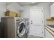 Functional laundry room equipped with stainless steel washer and dryer and ample storage at 14820 E Maplewood Dr, Centennial, CO 80016