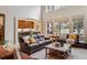 Bright living room featuring a comfortable seating area, large windows, and an open view to the kitchen at 14820 E Maplewood Dr, Centennial, CO 80016