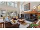 Bright living room with a cozy fireplace, large windows, and comfortable leather seating at 14820 E Maplewood Dr, Centennial, CO 80016