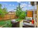 Serene backyard with a well-manicured lawn, mature trees, a wooden fence, and outdoor seating area at 9580 E 5Th Ave, Denver, CO 80230