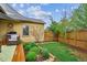Landscaped backyard with a wooden fence, green lawn, garden, and cozy seating area, ideal for outdoor activities at 9580 E 5Th Ave, Denver, CO 80230