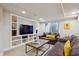 Finished basement featuring a built in entertainment center, sofa, table and stools at 9580 E 5Th Ave, Denver, CO 80230