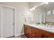 Bathroom with double sink vanity, wood cabinets, tile floors, and a large mirror at 9580 E 5Th Ave, Denver, CO 80230