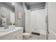 Well-lit full bathroom featuring a tub/shower combo, a gray color scheme, and a large vanity with storage at 9580 E 5Th Ave, Denver, CO 80230
