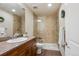 Modern bathroom with a granite countertop, walk-in shower, tiled walls and floors, and updated fixtures at 9580 E 5Th Ave, Denver, CO 80230