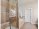 Bathroom featuring a glass enclosed shower, soaking tub with tile surround, and tile floors at 9580 E 5Th Ave, Denver, CO 80230