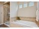 Bright bathroom featuring a soaking tub with mosaic tile backsplash and a separate glass-enclosed shower at 9580 E 5Th Ave, Denver, CO 80230