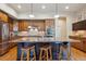 Well-lit kitchen featuring a granite countertop island with barstool seating and stainless steel appliances at 9580 E 5Th Ave, Denver, CO 80230