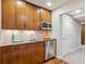 Kitchenette area featuring wooden cabinets, stone countertops, and stainless steel appliances at 9580 E 5Th Ave, Denver, CO 80230