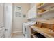 Convenient laundry room with washer, dryer, counter space, and storage shelves at 9580 E 5Th Ave, Denver, CO 80230